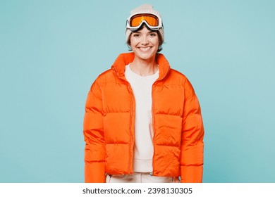 Young skier smiling happy cheerful woman wears warm padded windbreaker jacket hat ski goggles mask look camera travel rest spend weekend winter season in mountains isolated on plain blue background - Powered by Shutterstock