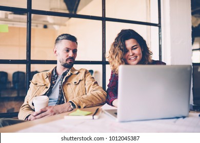 Young Skilled Female Student Presenting To Coach Her Project Using Laptop Computer During Informal Meeting, Colleagues Having Discussion Watching Video Online During Break In Coworking Office