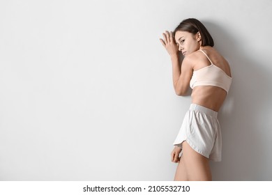 Young skinny woman on light background. Anorexia concept