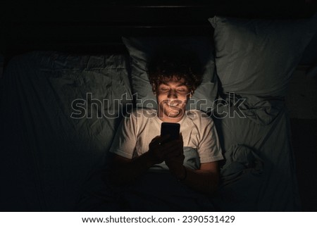 Similar – Image, Stock Photo Phone addiction. Man lying in bed with smartphone