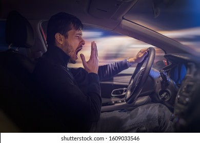 Young Sleepy Man Is Yawning And Driving Car At Night.