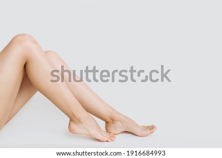 young slender legs of a woman on a white background copy the space. the concept of depilation of the skin