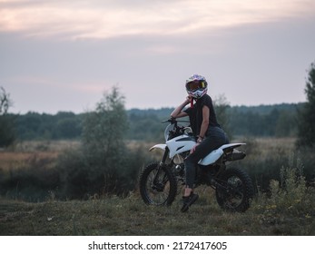 A Young Slender Woman In A Helmet On A Cross - Country Motorcycle Or Pit Bike . Moto Woman