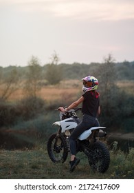 A Young Slender Woman In A Helmet On A Cross - Country Motorcycle Or Pit Bike . Moto Woman