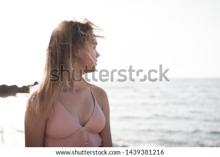 young slim beautiful woman in pink bikini on tropical beach. Portrait of happy young woman smiling at sea. Girl in swimwear enjoying and walking on beach.