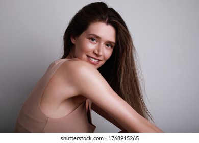 Young Slim Woman In Beige Cotton Top Looking And Smiling At The Camera. Body Positive And Health Concept.