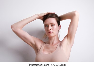 Young Slim Woman In Beige Top Showing Her Body Shape, Stretching Her Hair Up. Body Positive And Mental Health Concept.