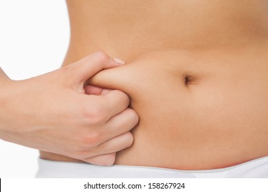 Young slim woman with little fat on her belly on white background