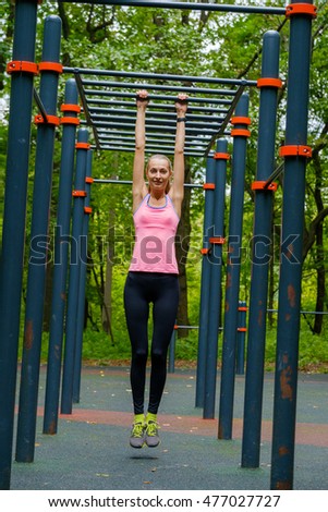 Young slim woman sports portrait on the training ground in a park