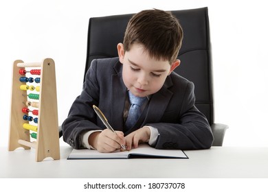 young small boy pretending he's working in an office with a abacus on his desk