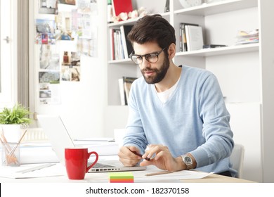 Young Small Business Owner Sitting At Desk And Working At Home.