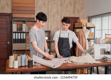 Young smart Asian LGBTQ men join work together partnership, small business starts up designer, friend design clothing new collection together,  freelancer work at home or office studio. Teamwork.