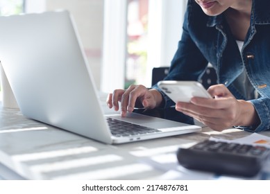 Young Smart Business Woman Busy Working, Using Mobile Phone And Laptop Computer At Modern Office. Woman In Casual Wear Online Working From Home Office, Telecommuting, Distance Job Concept