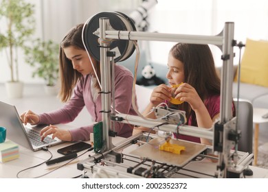 Young Smart Girls Learning 3D Printing At Home, They Are Using A 3D Printer And A Laptop, Science And Education Concept