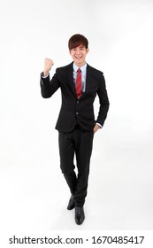 Young Smart Handsome Asian Man Business Office Wearing Suit Tie On White Background Walk Forward Fist Up Joy Success 