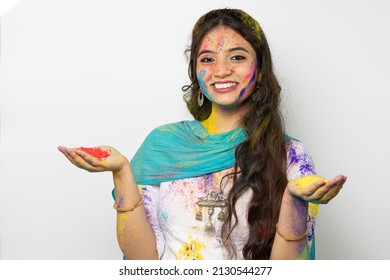 Young smart indian girl face coloured with gulal and hand full of color powder for festival of colours Holi, a popular hindu festival celebrated across india advertisement isolated white background - Powered by Shutterstock