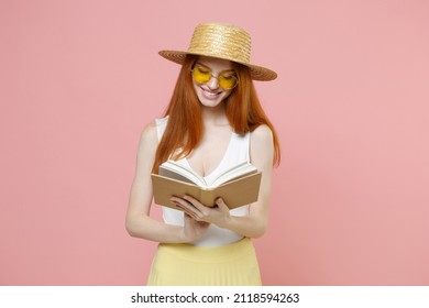 Young Smart Intelligent Redhead Smiling Student Woman 20s Ginger Wearing Straw Hat Glasses Summer Clothes Holding Reading Interesting Book Isolated On Pastel Pink Color Background Studio Portrait