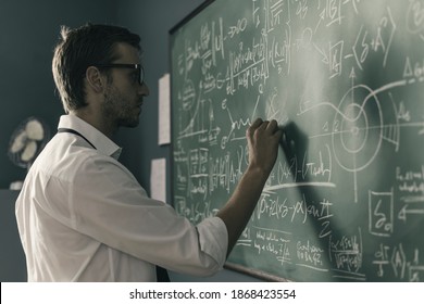 Young smart mathematician drawing math formulas on the chalkboard and thinking: he is solving problems and discovering new theories - Powered by Shutterstock