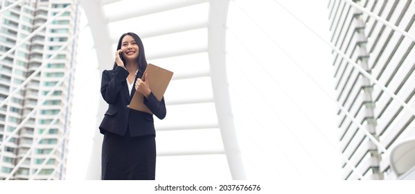 Young Smart Professional Asian Business Woman Using Mobile Phone In The City Outdoor