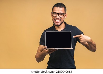 Young Smiling African American Black Man Standing And Using Laptop Computer Isolated Over Beige Background. Showing Pc Screen.