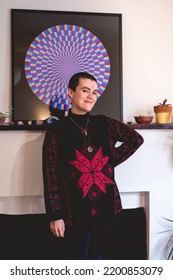 Young And Smiling Artist Girl With Very Short Hair, Bindi And Wool Sweater In Front Of His Beautiful Abstract Circle Painting