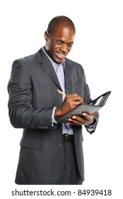 Young Smiling Black Businessman Taking Notes Isolated On A White Background