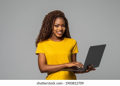 Young smiling black woman standing with laptop computer