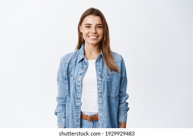 Young Smiling Blond Girl With Perfect Teeth Staring At Camera, Standing Relaxed Against White Background In Casual Clothes, Lifestyle And Emotions Concept