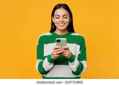 Young smiling brunette latin woman wear casual cozy green knitted sweater hold in hand use mobile cell phone in mint case isolated on plain yellow background studio portrait People lifestyle concept - Powered by Shutterstock