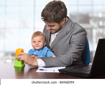 Young Smiling Business Man Holding His Little Baby Son