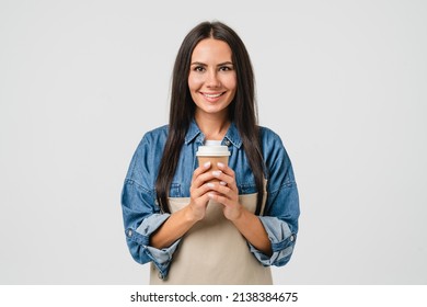 Young Smiling Caucasian Female Barista Bar Tender Coffee Maker Woman In Apron Holding Paper Coffee Cup, Selling Hot Beverage Tea Isolated In White Background.