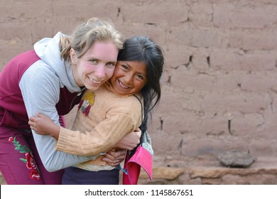 Young Smiling Caucasian Woman Huggung Native American Little Girl In The Countryside.