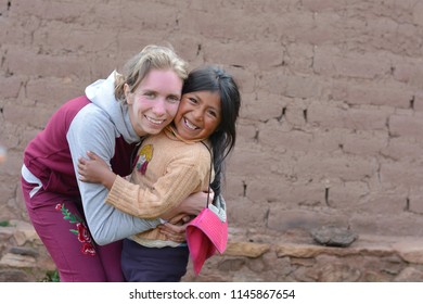 Young Smiling Caucasian Woman Huggung Native American Little Girl In The Countryside.