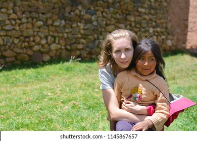 Young Smiling Caucasian Woman Huggung Native American Little Girl In The Countryside.