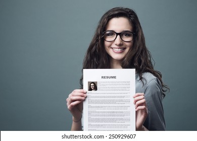 Young smiling cheerful woman holding her resume - Shutterstock ID 250929607
