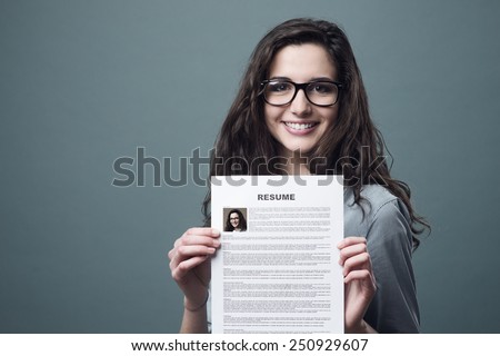 Young smiling cheerful woman holding her resume