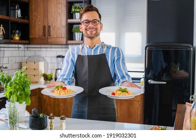Young smiling chef showing freshly home made tomato and basil pasta - Powered by Shutterstock