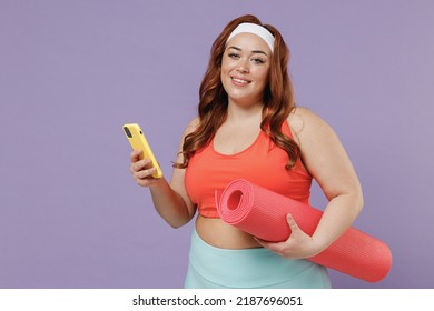 Young Smiling Chubby Overweight Plus Size Big Fat Fit Woman In Red Top Warm Up Training Hold Yoga Mat Mobile Cell Phone Isolated On Purple Background Studio Home Gym Workout Sport Motivation Concept