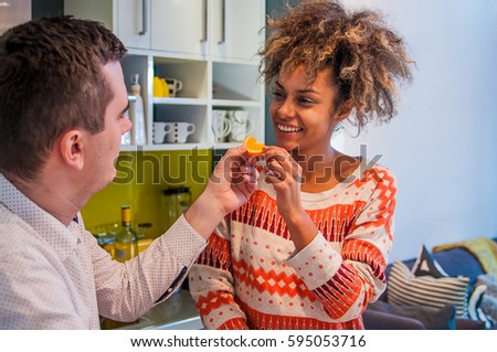 Young smiling couple eating healthy food. Happy Couple Eating fresh fruits.Having fun on a kitchen.Dieting concept.Healthy eating