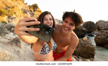 Young smiling couple having fun on the beach taking selfie with the smart phone.  - Powered by Shutterstock