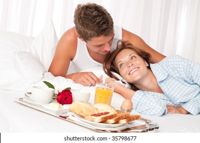 Young Smiling Couple Having Luxury Breakfast In Hotel Room