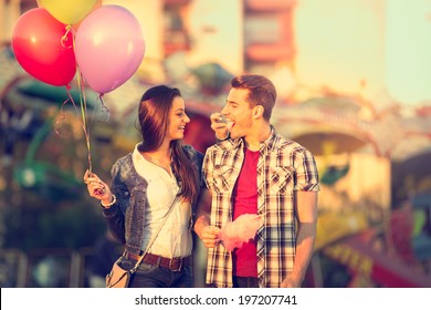 Young Smiling Couple Having A Ride On A Ferris Wheel