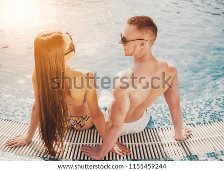 Young Smiling Couple near Swimming Pool in Summer. Leisure in Summer. Relaxation for Family Outdoor. Vacation in Summer. Recreation Concepts. Boyfriend and Girlfriend. Vacation for Couple.