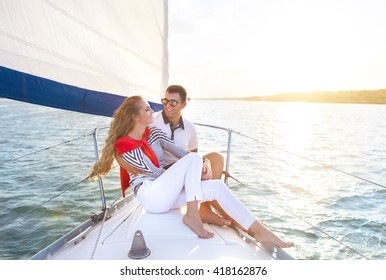 Young Smiling Couple On A Sailing Boat At Summer Sunset