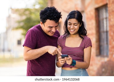 Young smiling couple on street using mobile.  - Shutterstock ID 1964132068