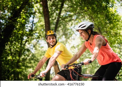 Young smiling couple riding bicycles