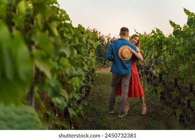 Young smiling couple tasting wine at winery vineyard - Powered by Shutterstock