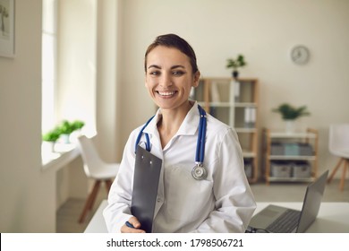 Young smiling doctor therapist standing and looking at camera over medical clinic office at background - Shutterstock ID 1798506721