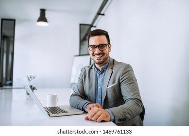 Young smiling entrepreneur in bright office working on laptop. - Shutterstock ID 1469761133