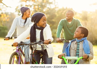 Young Smiling Family Doing A Bike Ride On An Autumns Day